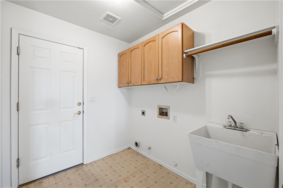 2853 Winchester Road Bullhead City, AZ 86442 - Photo 27 of 40 Dedicated utility space featuring light wood-finish cabinetry, a utility sink, and laundry hookups