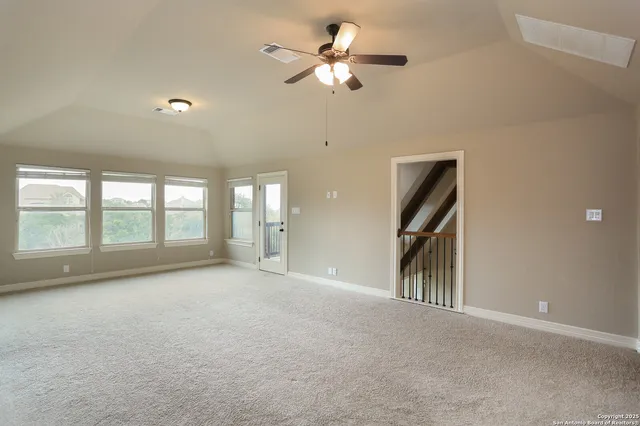 a view of n empty room with window and ceiling fan