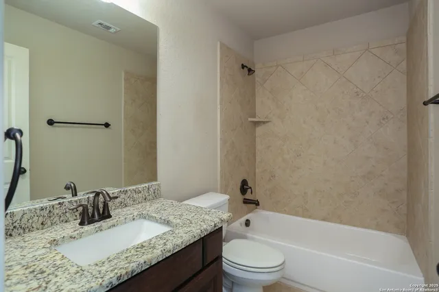 a bathroom with a granite countertop sink toilet and shower