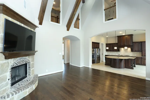 a view of a kitchen with a stove wooden cabinets and a fireplace