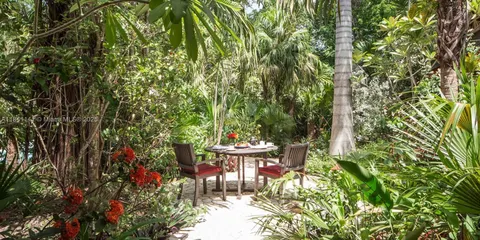 a view of a table and chairs in a backyard of a house