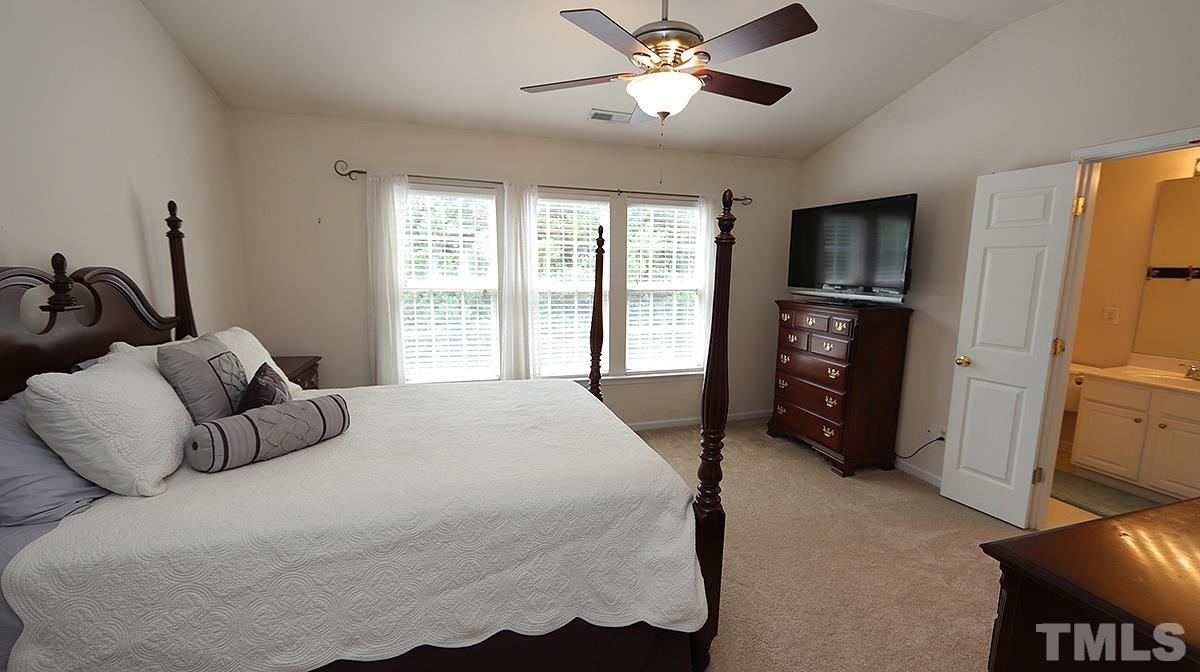 7225 Galon Glen Road Raleigh, NC 27613 - Photo 14 of 20 a bedroom with a bed and a chandelier