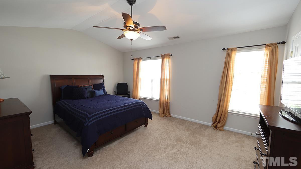 7225 Galon Glen Road Raleigh, NC 27613 - Photo 17 of 20 a bedroom with a bed and a chandelier