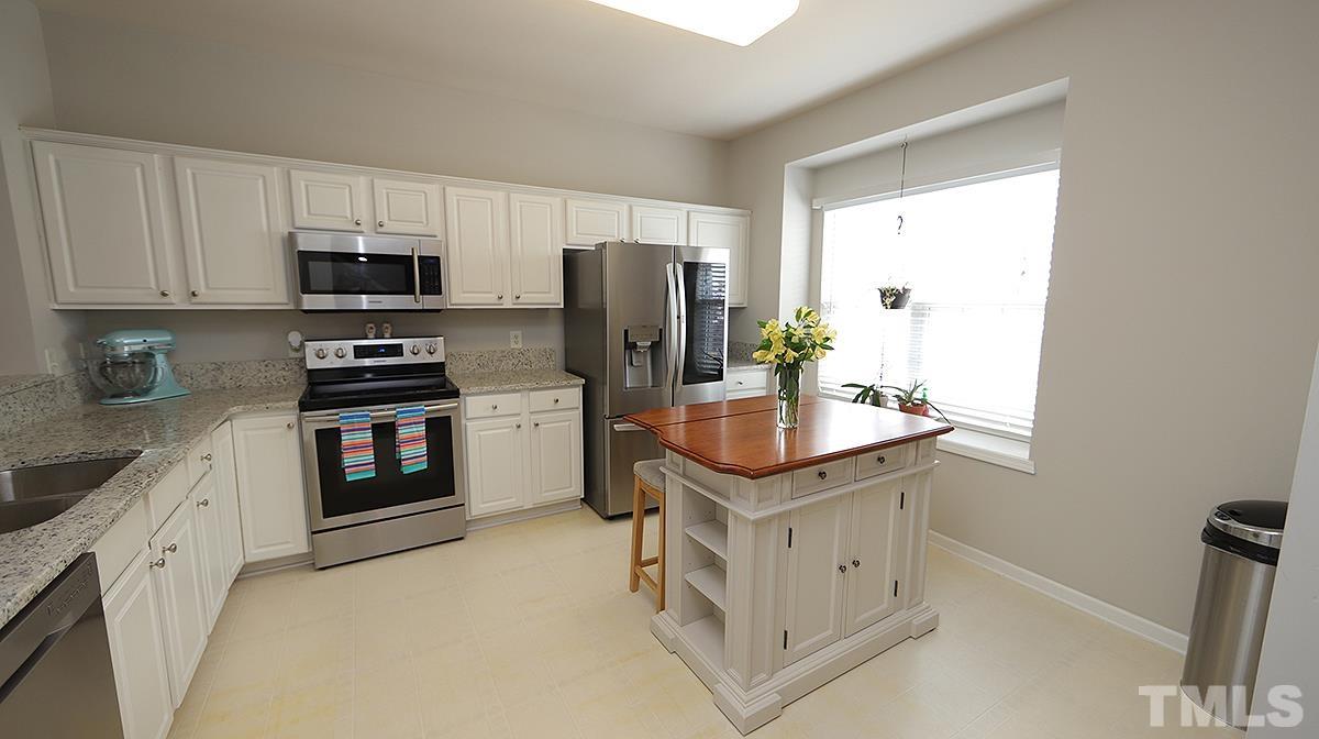 7225 Galon Glen Road Raleigh, NC 27613 - Photo 5 of 20 a kitchen with stainless steel appliances a stove refrigerator sink and microwave