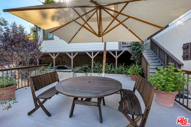 a view of backyard with seating space and wooden fence