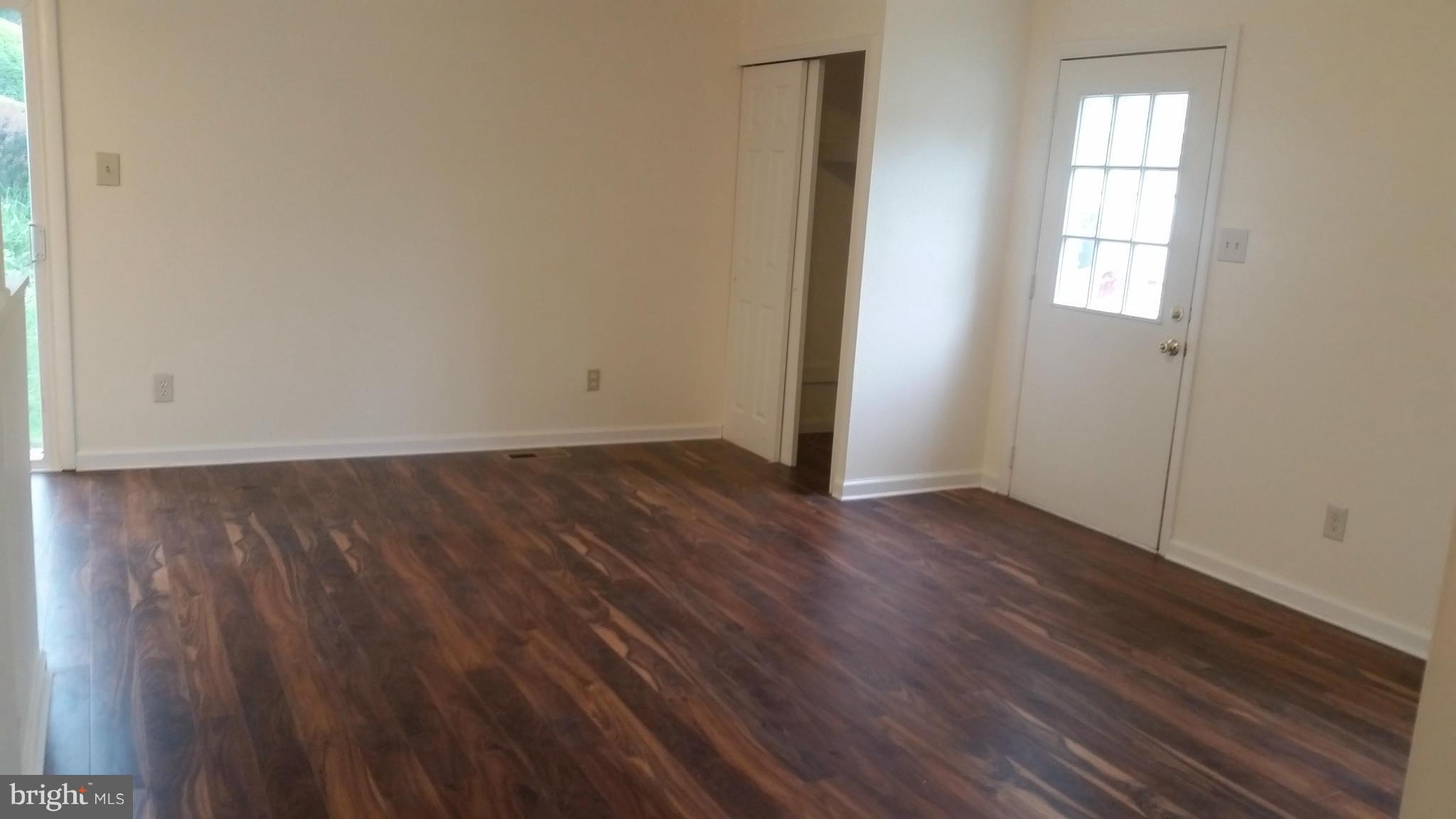 98 Ridgelawn Road, Unit A Reisterstown, MD 21136 - Photo 3 of 22 an empty room with wooden floor and windows