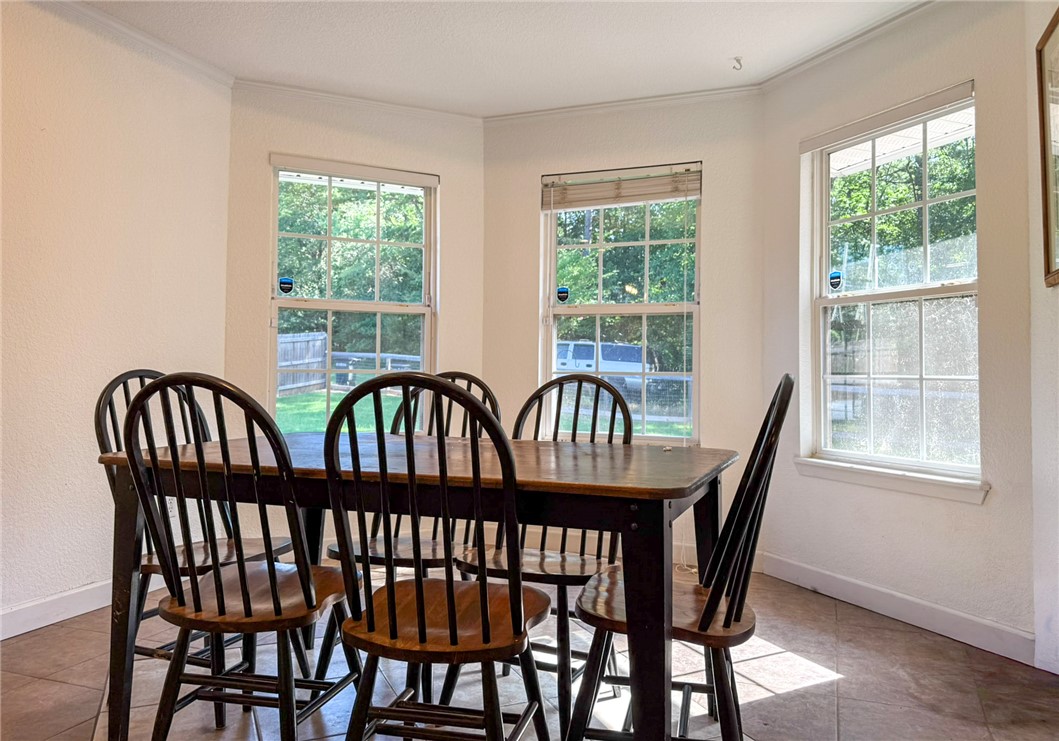 70 Walthall Road Russellville, AR 72802 - Photo 6 of 51 Dining area featuring multiple windows, crown molding, and tile flooring