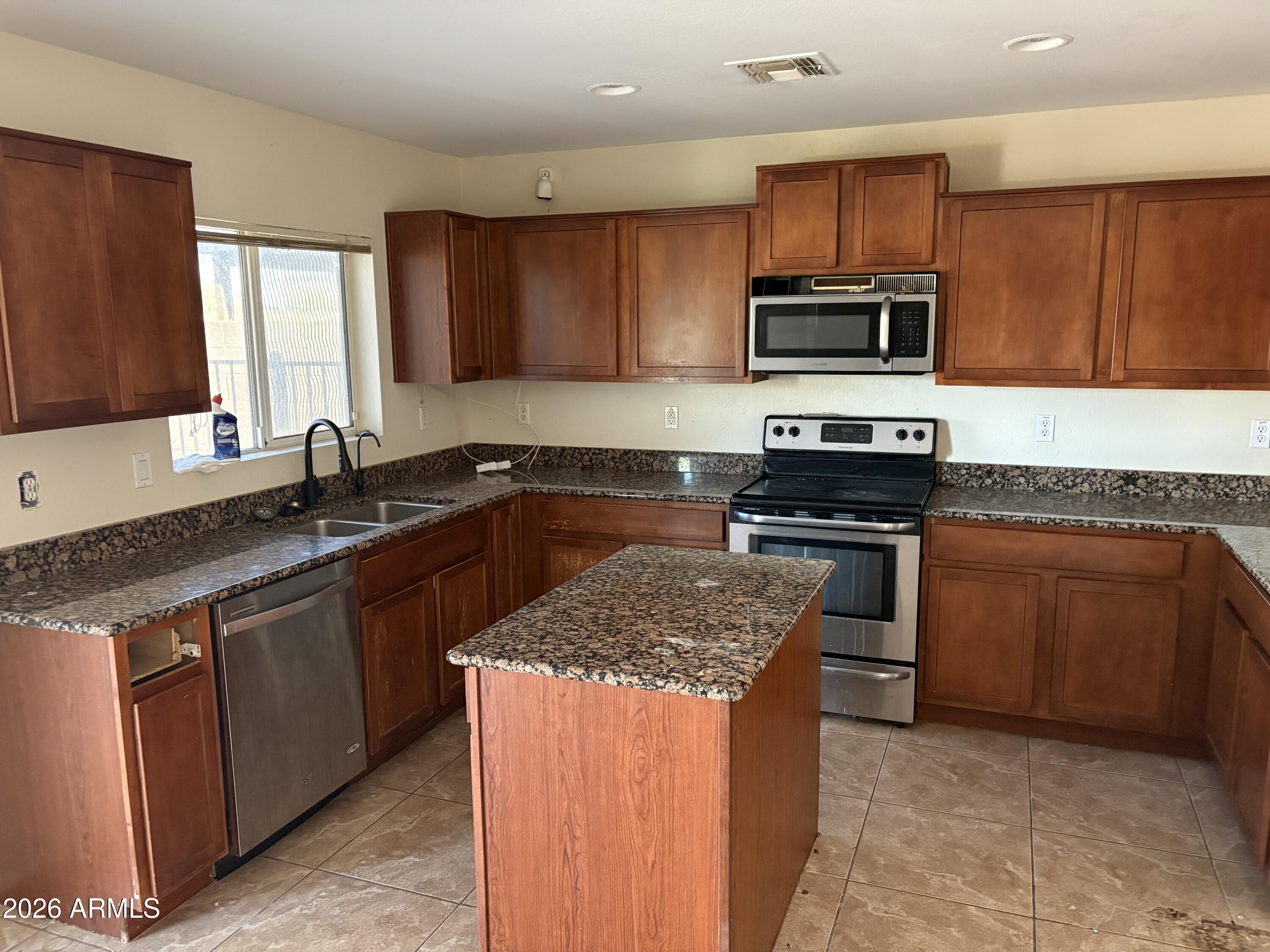 5222 East Silverbell Road San Tan Valley, AZ 85143 - Photo 5 of 16 a kitchen with stainless steel appliances granite countertop a sink stove microwave and refrigerator