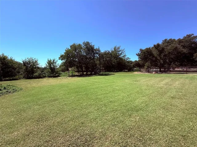 a view of a field with trees in the background