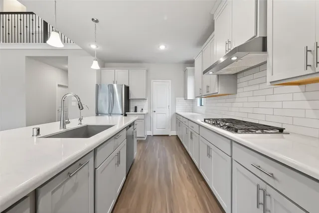 a kitchen with stainless steel appliances granite countertop a sink stove and cabinets