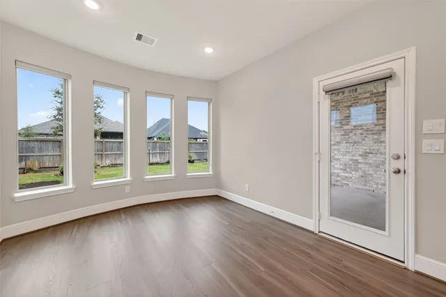 wooden floor in an empty room with a window