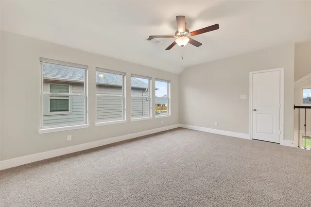 an empty room with a window and a fan