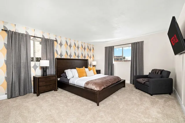 a bedroom with a bed flat screen tv and window