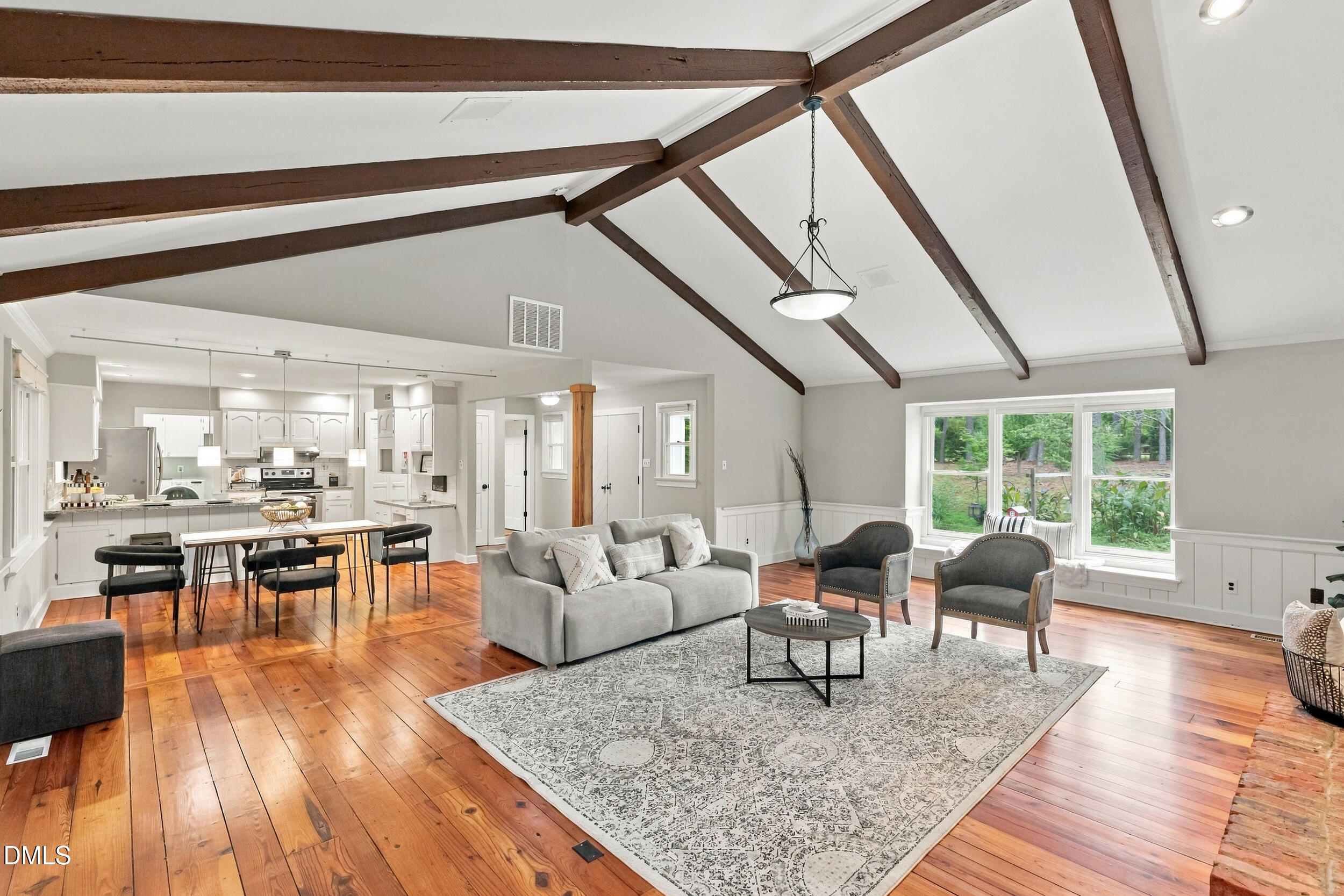 2329 Win Road Garner, NC 27529 - Photo 20 of 90 Vaulted ceilings with exposed beams, wood-finish flooring, a kitchen with white cabinetry, stainless steel appliances, and a dining area