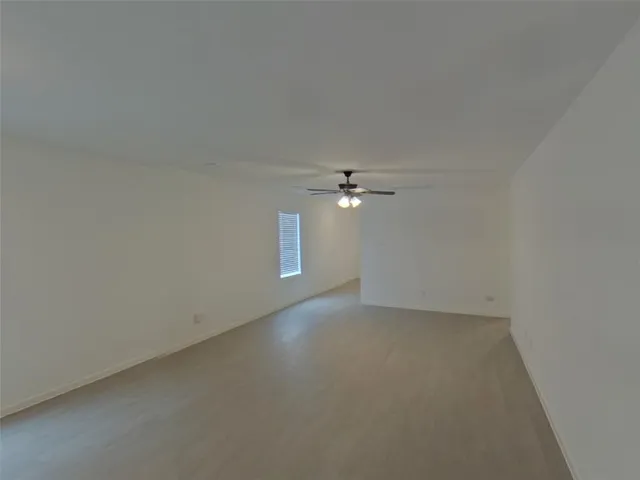 an empty room with a empty space and a ceiling fan