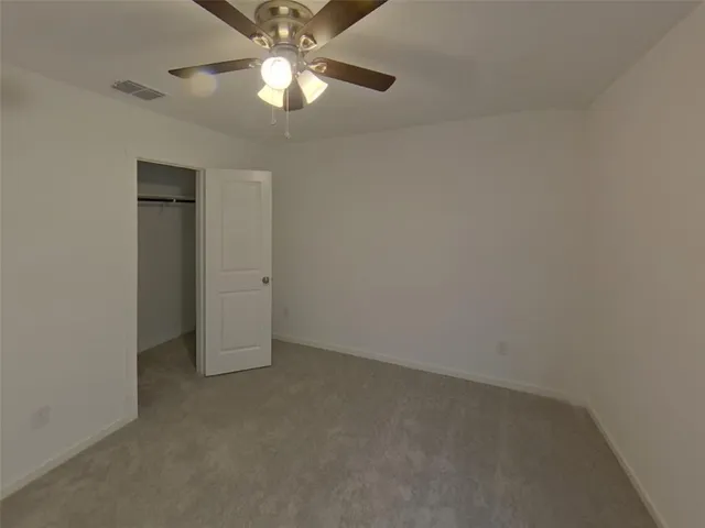 an empty room with a fan and a ceiling fan