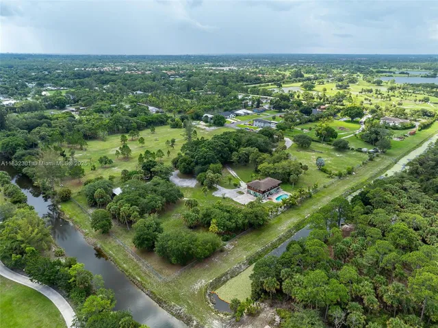 an aerial view of residential houses with outdoor space and trees