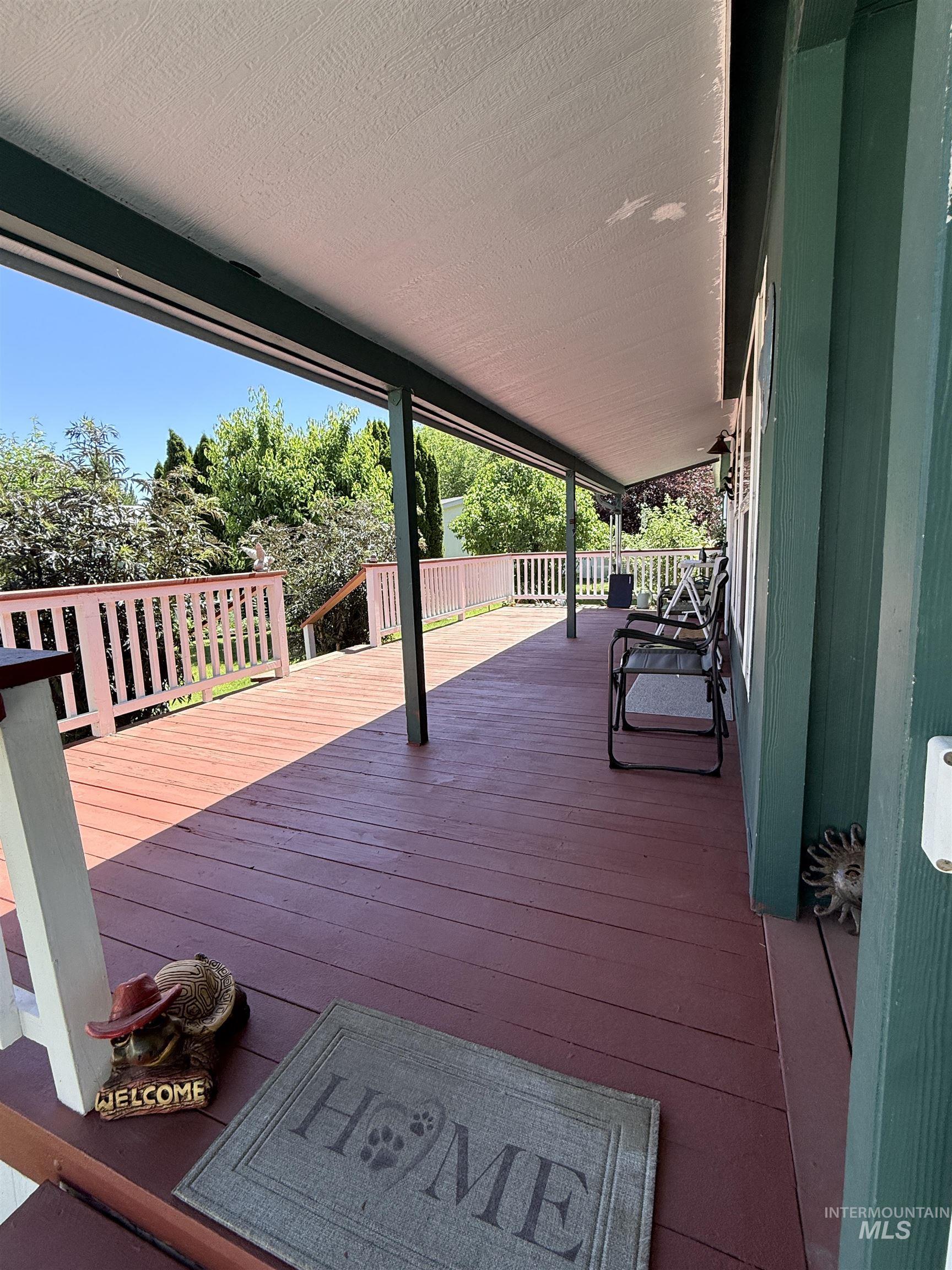 2750 Alden Road, Unit 12 12 Fruitland, ID 83619 - Photo 6 of 38 Expansive covered deck featuring wood-finish decking, white railings, and a solid overhead covering