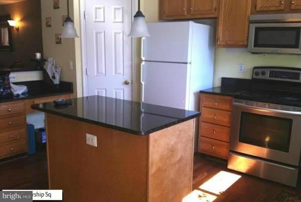 45053 Fellowship Square Ashburn, VA 20147 - Photo 8 of 9 a kitchen with stainless steel appliances granite countertop a stove a sink and a microwave