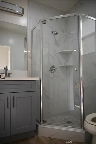a bathroom with a shower sink vanity and toilet