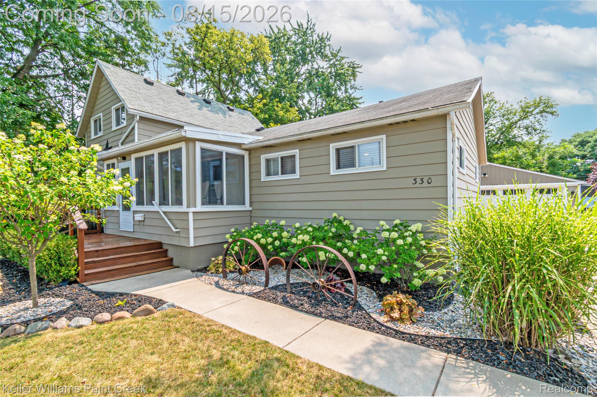 Siding exterior with a screened porch, wooden steps, and a concrete walkway