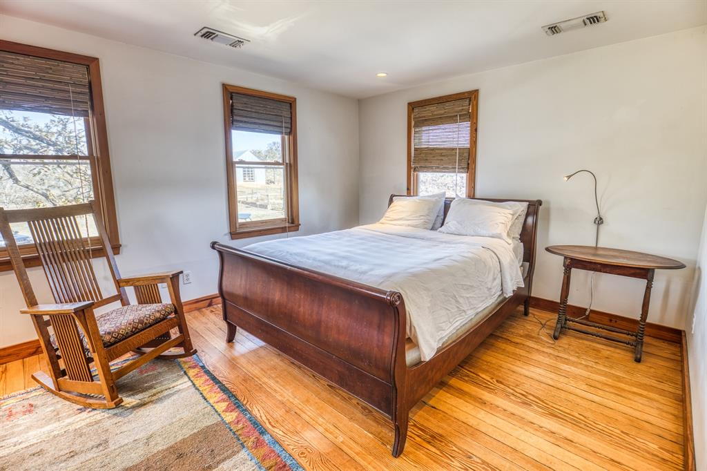 2969 County Lane Talpa, TX 76882 - Photo 19 of 40 a bedroom with a bed a chair and next to a window