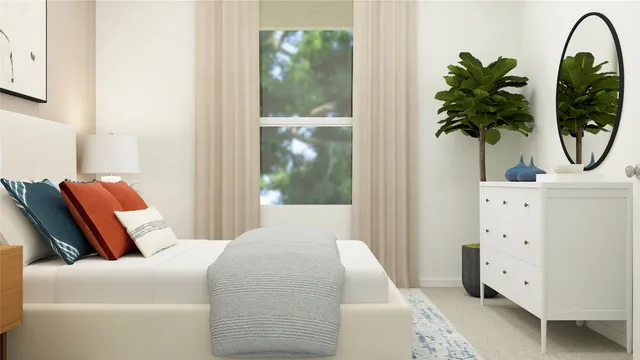 a bedroom with a bed and a potted plant