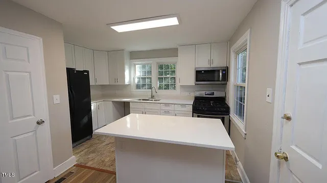 a kitchen with a refrigerator a stove top oven a sink and dishwasher