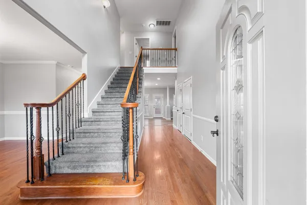 a view of an empty room with wooden floor fireplace and a window