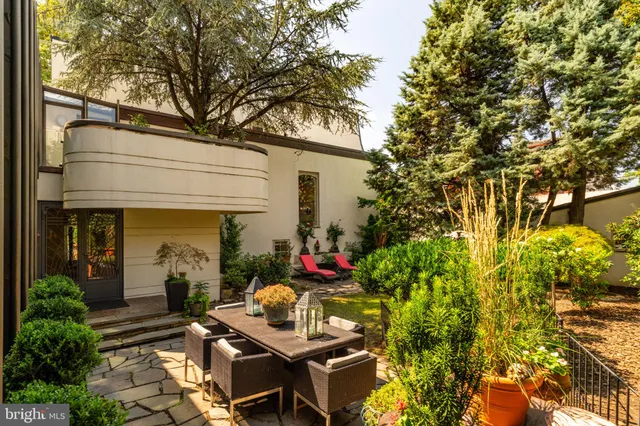 a view of a backyard with plants and chairs