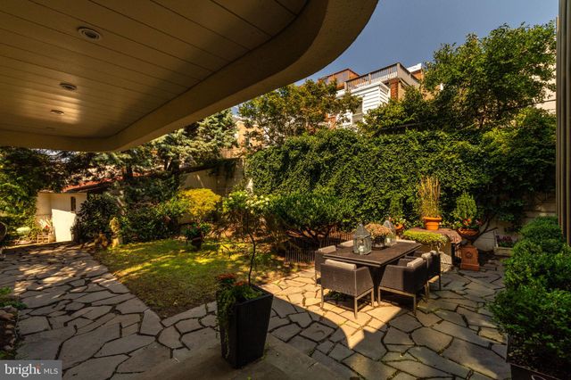a vase of flowers sitting on a table in front of a house