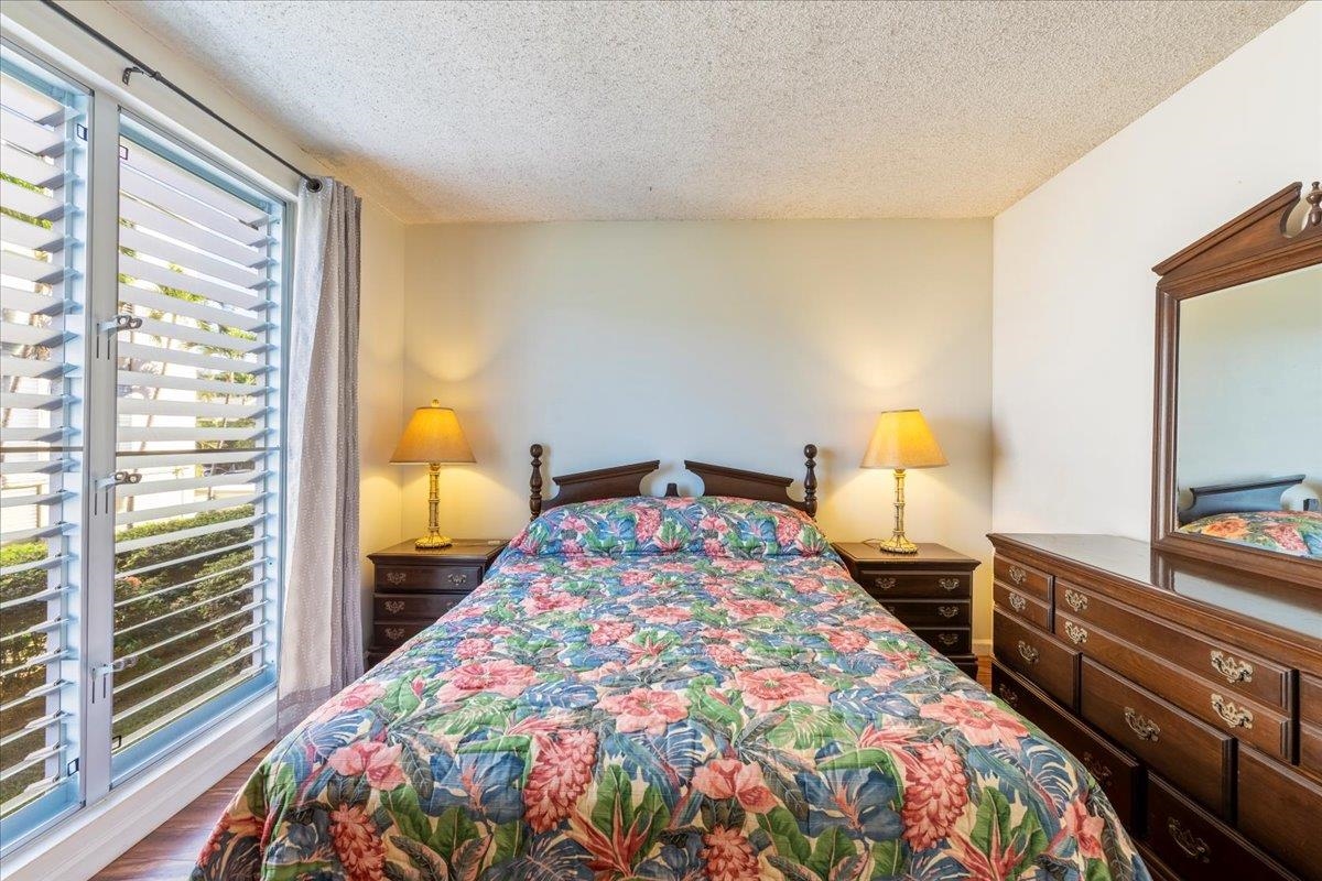 1002 South Kihei Road, Unit 212 Kihei, HI 96753 - Photo 19 of 50 a bedroom with a bed and a flat tv screen on dresser
