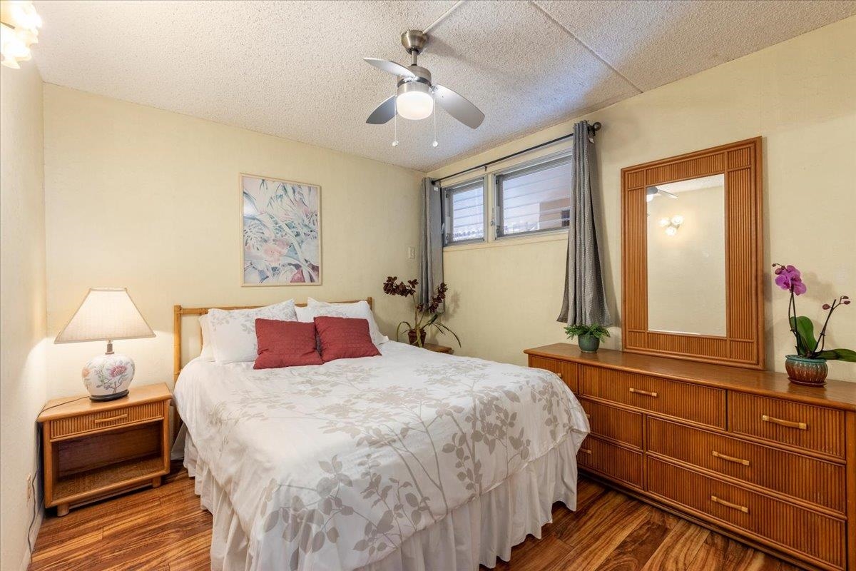 1002 South Kihei Road, Unit 212 Kihei, HI 96753 - Photo 22 of 50 a bedroom with a bed and a chandelier
