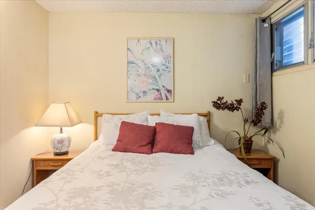 a bedroom with a bed and a painting on the wall