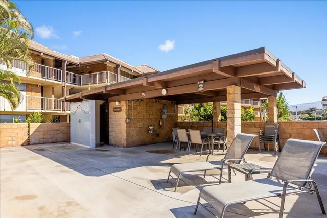 a patio with a table and chairs under an umbrella