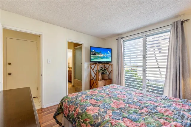 a bedroom with a large bed and a chandelier