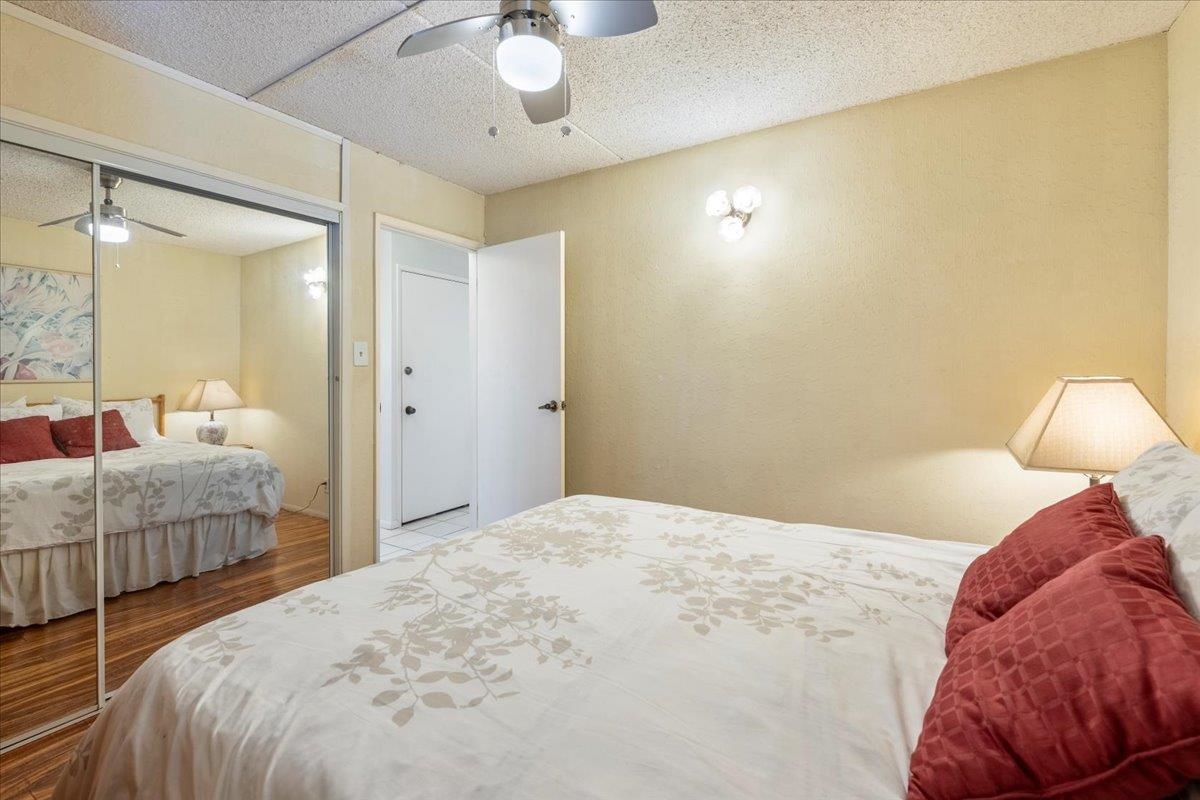 1002 South Kihei Road, Unit 212 Kihei, HI 96753 - Photo 41 of 50 a bedroom with a bed and a chandelier