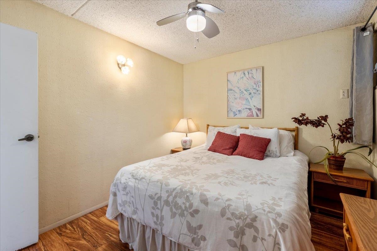1002 South Kihei Road, Unit 212 Kihei, HI 96753 - Photo 42 of 50 a bedroom with a bed and a chandelier