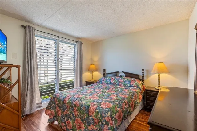 a bedroom with a bed and wooden floor