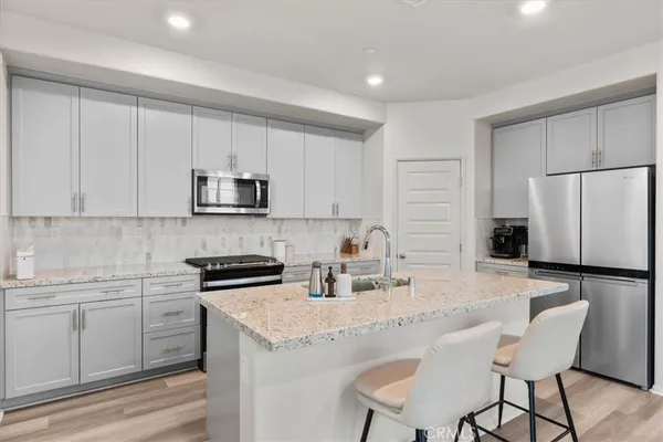 a kitchen with a sink a stove a refrigerator and white cabinets
