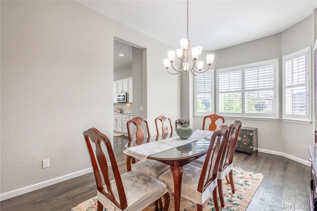 a view of a dining room with furniture wooden floor and chandelier