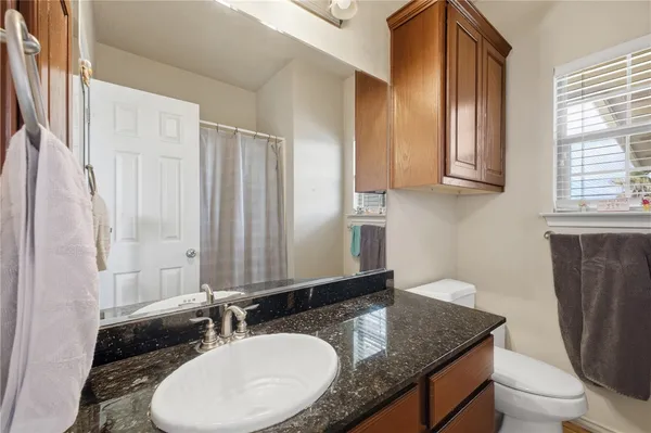 a bathroom with a granite countertop sink and a mirror