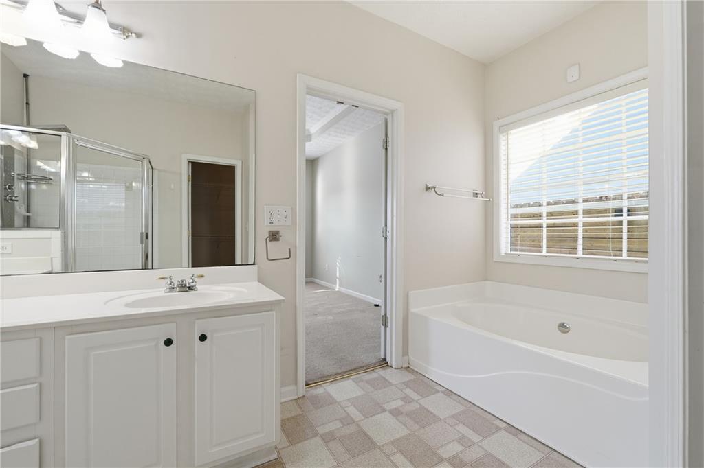 1402 Edgeley Way Lawrenceville, GA 30044 - Photo 17 of 23 a bathroom with a tub sink and mirror