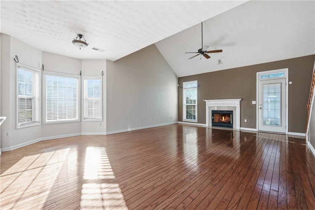 1402 Edgeley Way Lawrenceville, GA 30044 - Photo 6 of 23 an empty room with wooden floor fireplace and windows