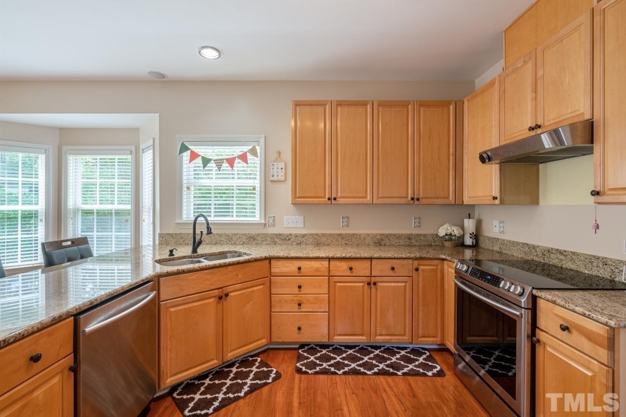 7921 Strawberry Meadows Street Raleigh, NC 27613 - Photo 8 of 30 a kitchen with a sink stove and cabinets
