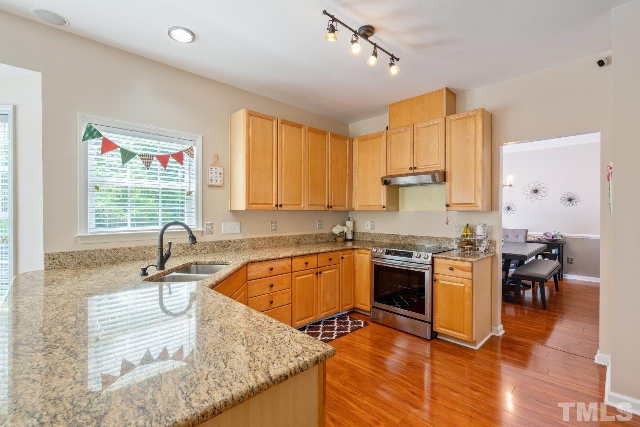7921 Strawberry Meadows Street Raleigh, NC 27613 - Photo 9 of 30 a kitchen with stainless steel appliances granite countertop a sink a stove and cabinets