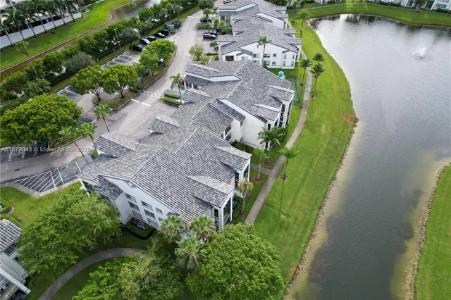an aerial view of a house with a yard and lake view