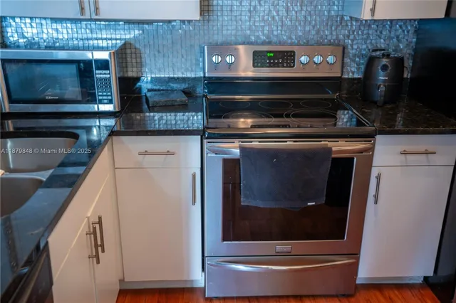 a stove top oven sitting inside of a kitchen