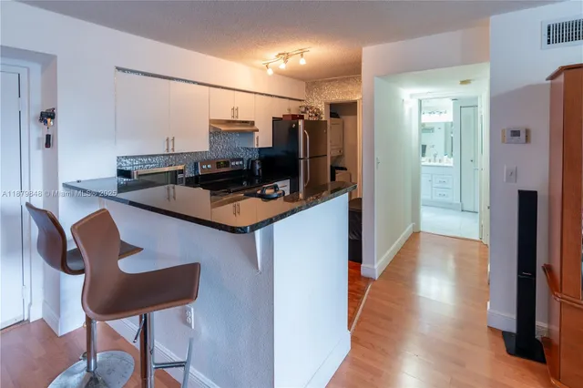 a kitchen with stainless steel appliances a refrigerator and a chair