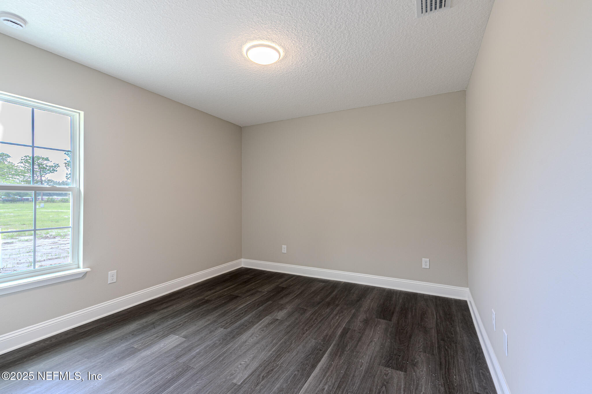451624 Old Dixie Highway Callahan, FL 32011 - Photo 13 of 20 a view of an empty room with wooden floor and a window
